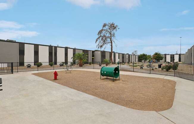 A playground with a red fire hydrant and a green slide.