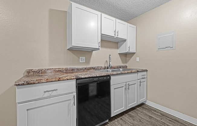 Modern kitchen with elegant white cabinetry and granite countertops, featuring a double sink.