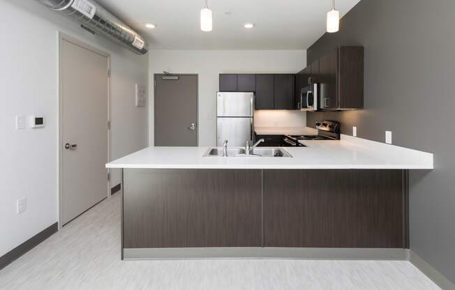 Modern open-concept kitchen and living area with stainless steel appliances.