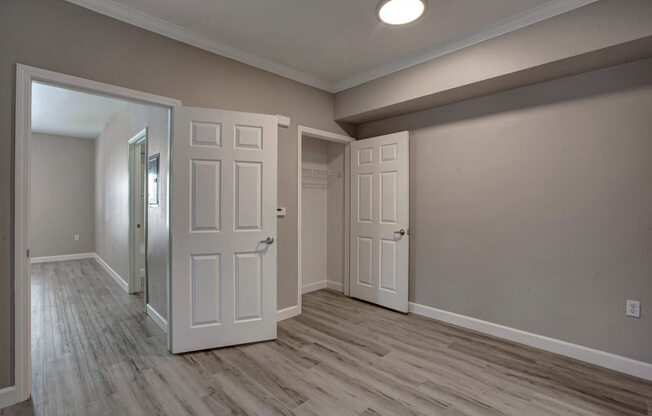a bedroom with two doors and a door to a bathroom