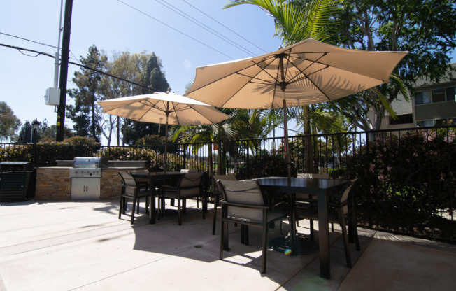 A patio with a table and chairs under a large umbrella.