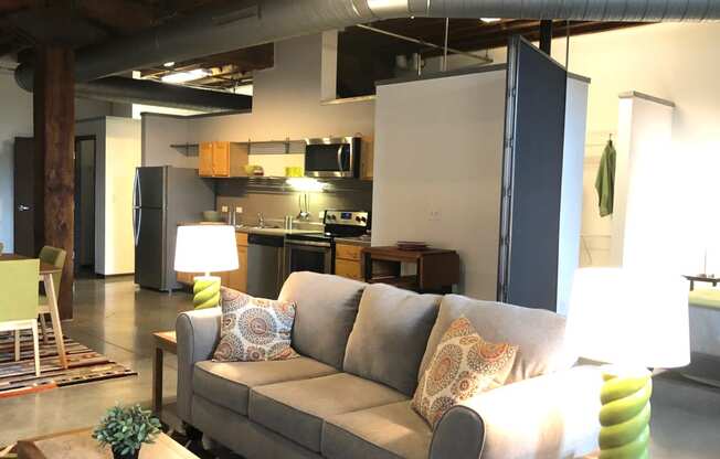 a living room with a couch and a kitchen in the background