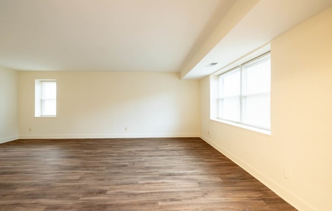 a bedroom with hardwood flooring and two windows  at Charlesgate Apartments, Towson, 21204