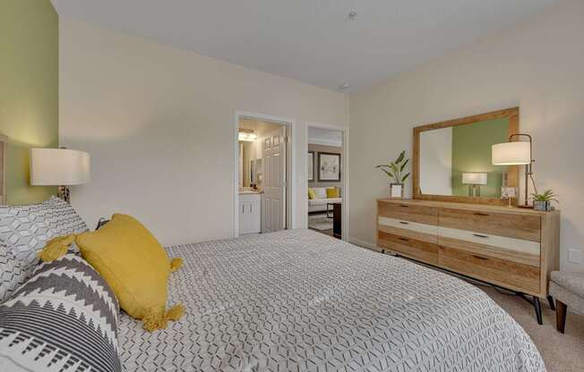 A bedroom with a bed, dresser, and mirror.