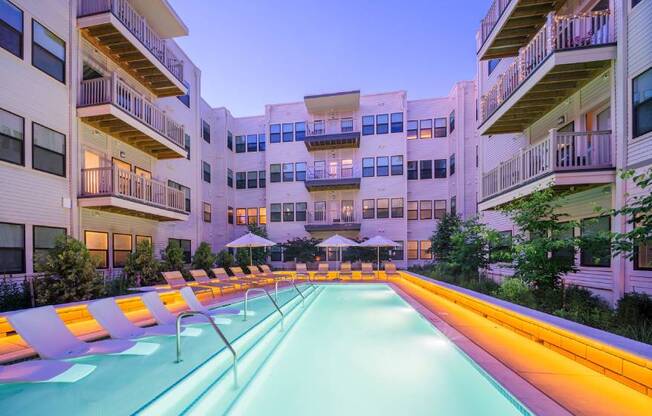 A long, narrow pool is the centerpiece of a courtyard surrounded by apartment buildings.