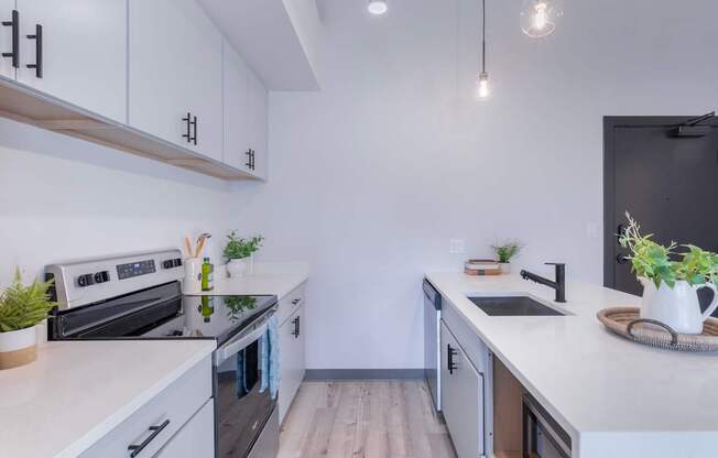 A modern kitchen with white cabinets and a black oven.