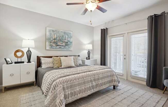 A bedroom with a large bed and a ceiling fan.