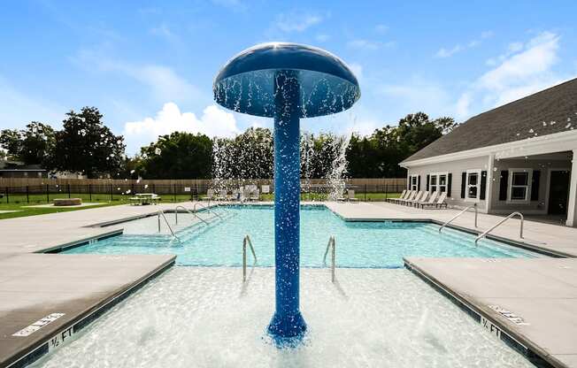 A blue water fountain in the middle of a pool.