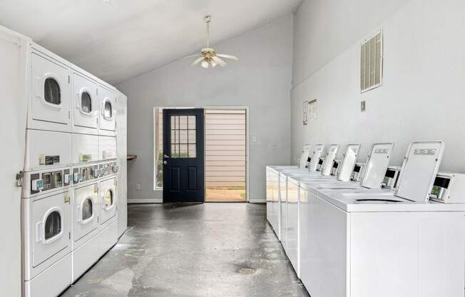 a white laundry room with washers and dryers
