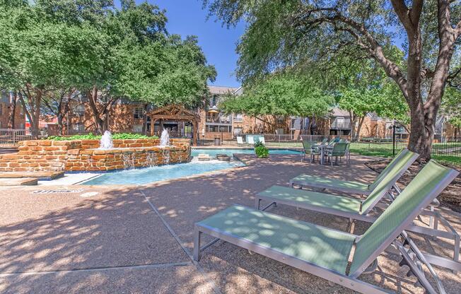 an empty park bench next to a tree