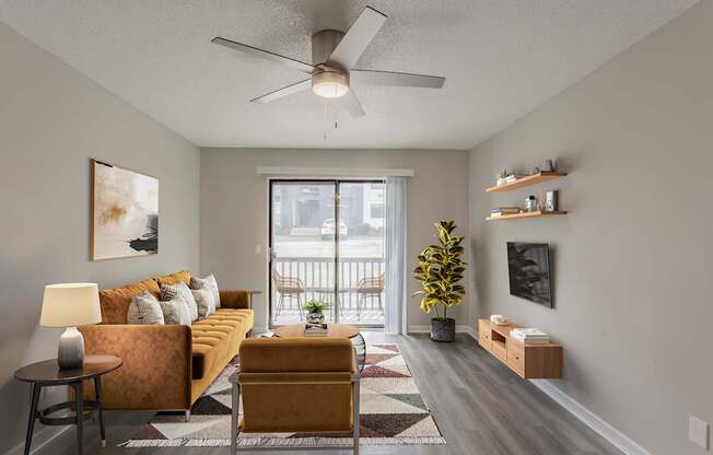 A living room with a yellow couch and a ceiling fan.