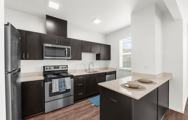 a kitchen with dark wood cabinetry and stainless steel appliances