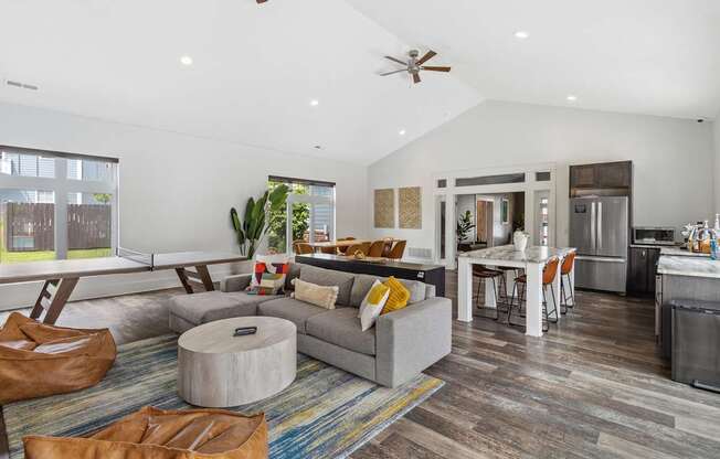 A modern living room with a grey couch and a round ottoman.