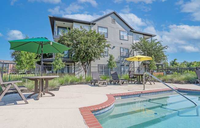 Pool steps with tables shaded by umbrellas surrounding pool at Ultris Island Park in Shreveport, LA