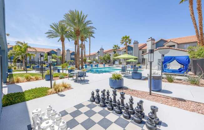 a giant chess board is set up in front of the pool at the whispering winds apartments in