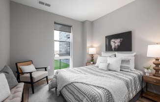 bedroom with gray walls and a large bed with white comforter and pillows