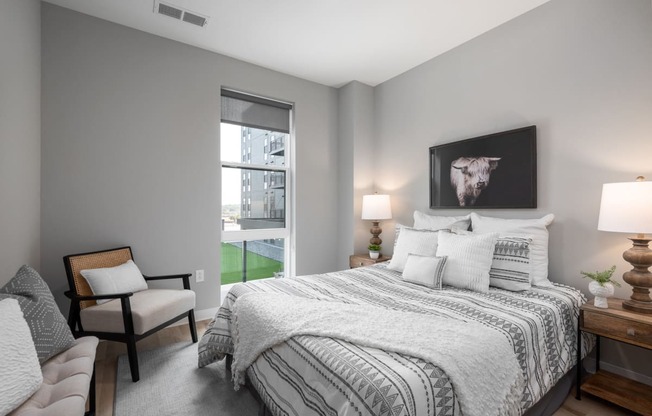 bedroom with gray walls and a large bed with white comforter and pillows