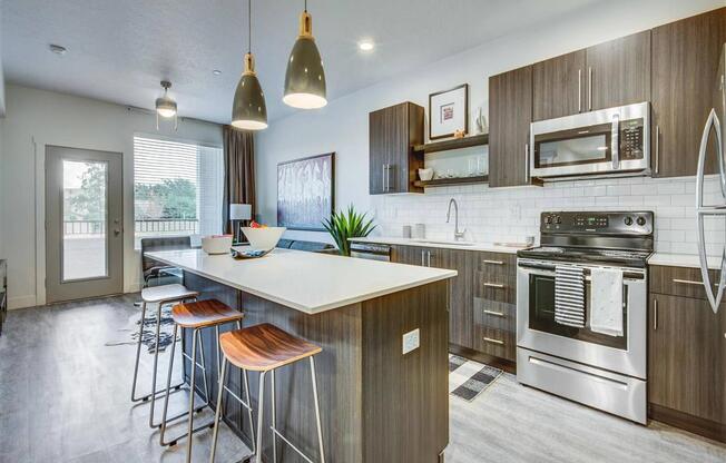 a kitchen with a large island with stools  at Affinity 56 Apartments in West Jordan, Utah