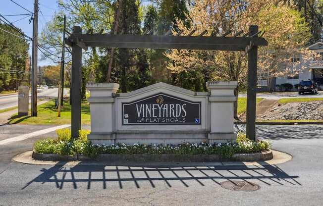 A sign for Vineyards Plate Schools is in front of a building.