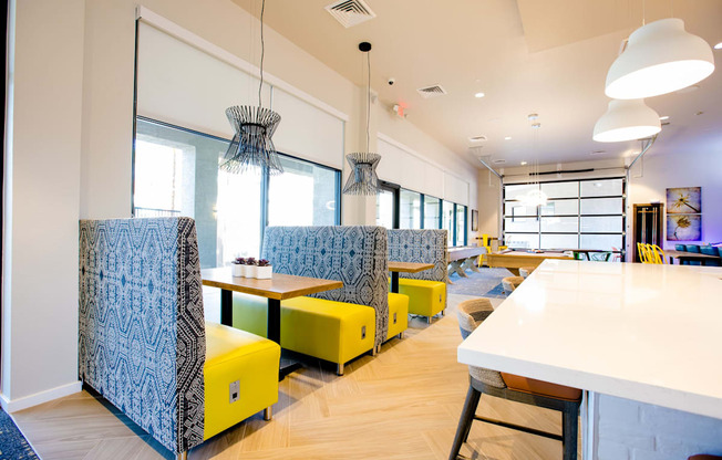 a seating area with yellow chairs and tables in a restaurant