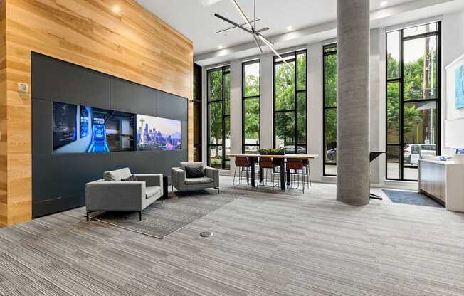 A modern waiting room with a TV on the wall and comfortable seating.