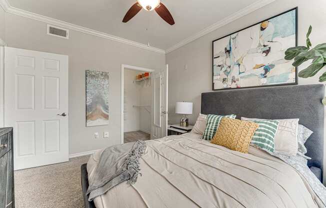 A bedroom with a large bed and a ceiling fan.
