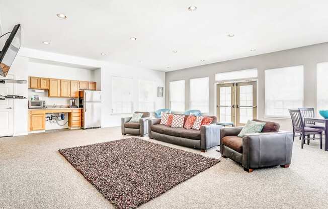 Clubhouse Lounge with Armchairs and Kitchen with Wood Cabinets and Stainless Steel Appliances