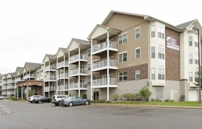 Apartment building with cars parked in front.