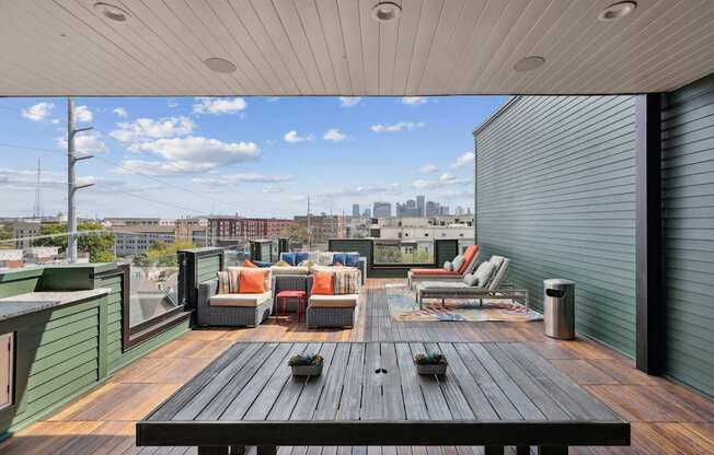 A wooden table is in the middle of a rooftop patio.