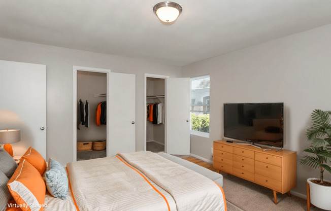 A bedroom with a bed, dresser, and mirror.