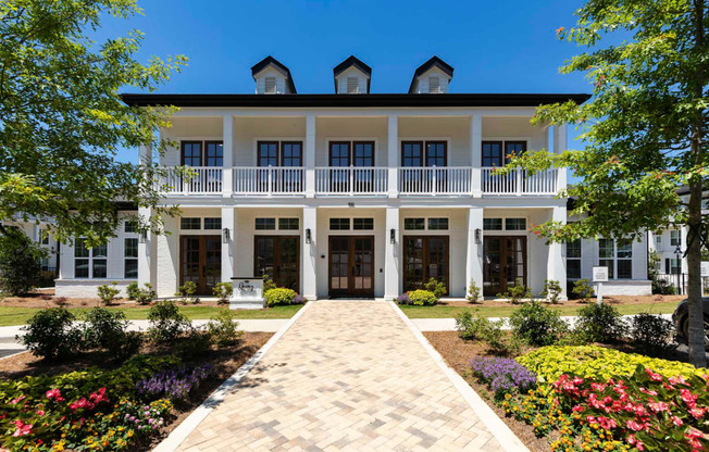 a large white house with a brick walkway in front of it at The Quincy Apartments, Acworth