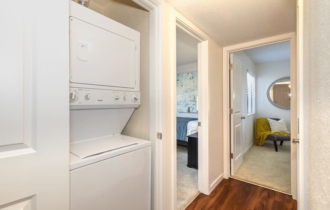 a laundry room with a washer and dryer and a door to a bedroom at Rocklin Manor  Apartments, California, 95677