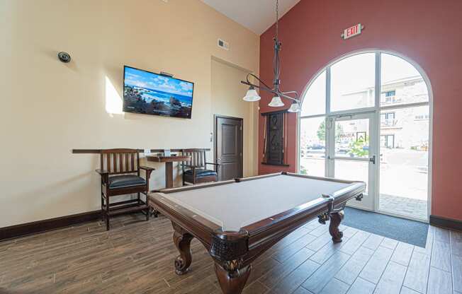 a games room with a pool table and a tv