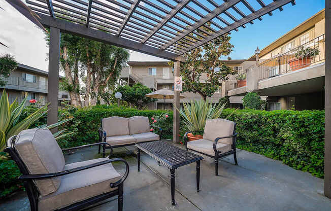 A patio with a table and chairs under a roof.