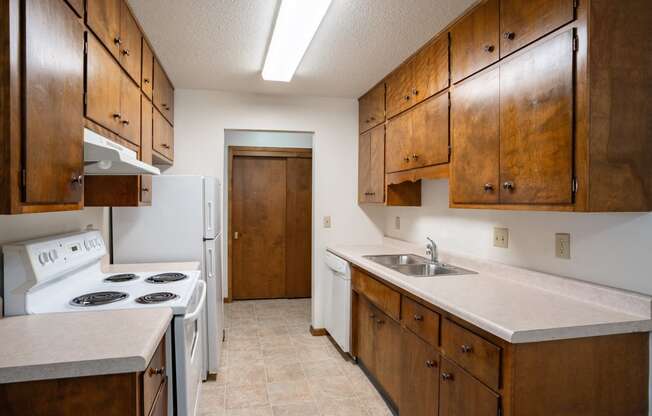 a kitchen with white appliances and wooden cabinets. Fargo, ND Hawn Apartments