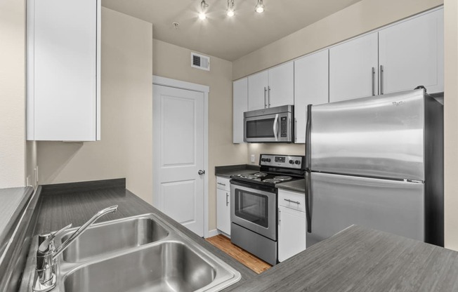 a kitchen with white cabinets and stainless steel appliances