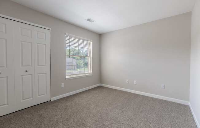 an empty room with carpet and a door and window