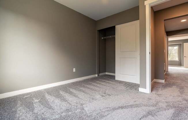 A room with a carpeted floor and a white door.
