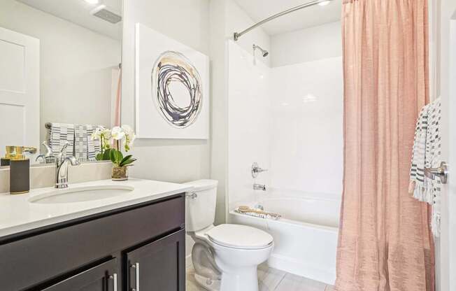 A bathroom with a toilet, sink, and shower. at Connect at First Creek Apartments, Denver, CO