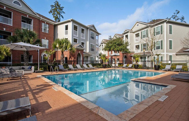 a large swimming pool in front of an apartment building at Volare at the Woodlands, The Woodlands, Texas