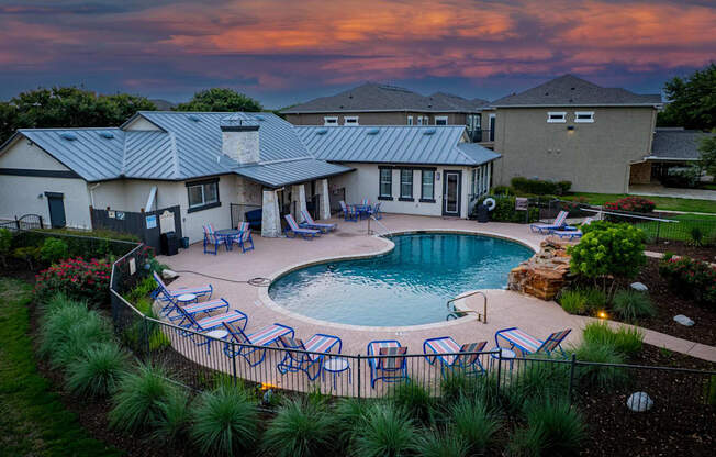 A house with a pool surrounded by a fence.
