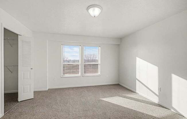 A large bedroom with a carpeted floor and a walk-in closet  at West Hampton Park Apartment Homes, Nebraska, 68022