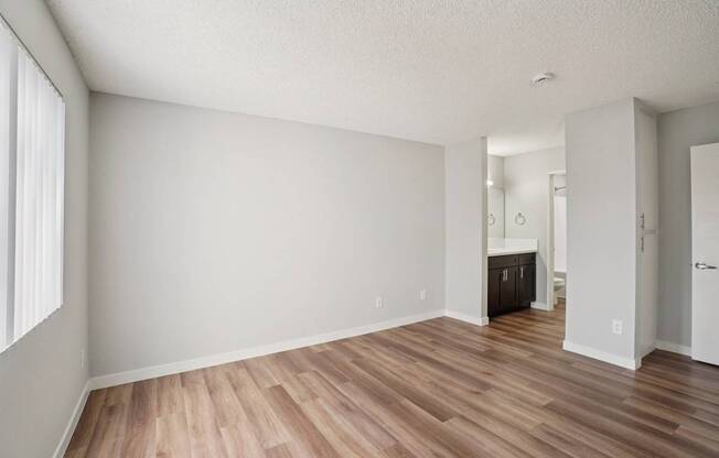 A room with wooden flooring and white walls.