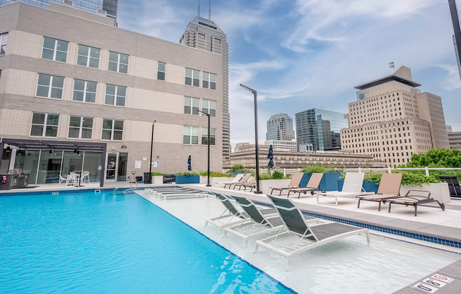 a swimming pool with a city skyline in the background