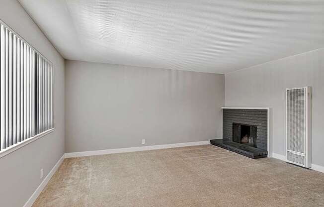 A room with a fireplace and a window with blinds.