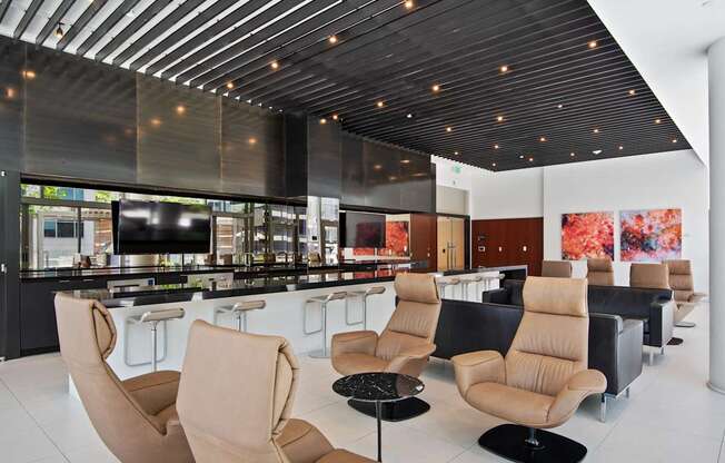 A modern lounge area with tan chairs and a black table.