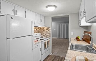 a kitchen with white appliances and a sink and a refrigerator