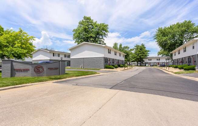A street view of a residential area with houses and a sign that reads at Spring Creek Townhomes Apartments, Springfield, Illinois