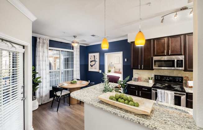 A kitchen with a table and chairs in front of a window.