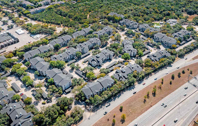 A bird's eye view of a residential area with houses and a highway.